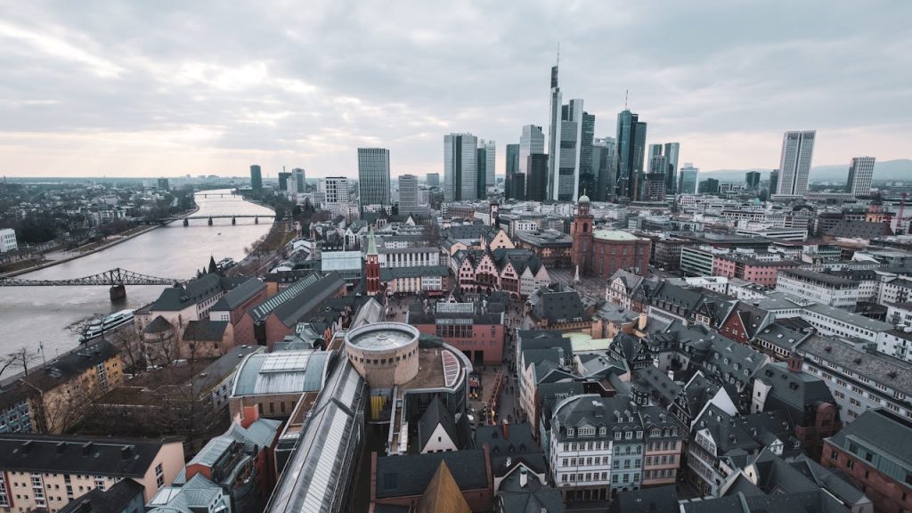 pexels photo 12323350 Captivating aerial view of Frankfurt am Main skyline with river and skyscrapers, under a moody sky.